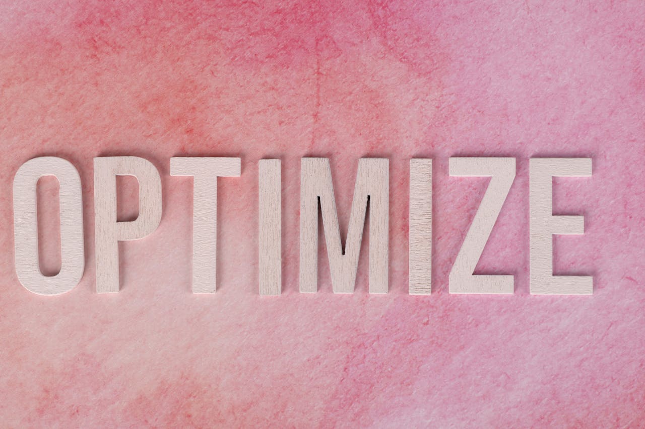 gallery-04 Creative display of the word OPTIMIZE on a pink textured surface.