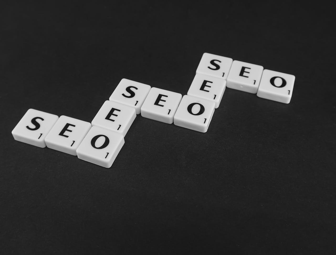 home-img SEO spelled with Scrabble tiles on a black surface, representing search engine optimization concepts.